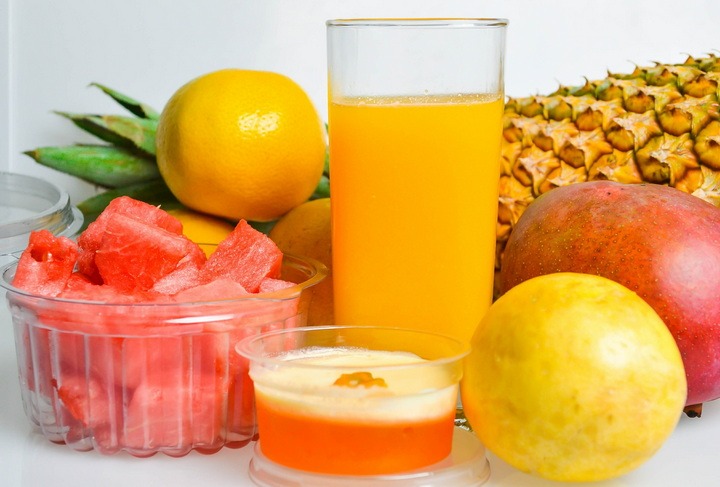 A picture of fruit and a glass of orange juice